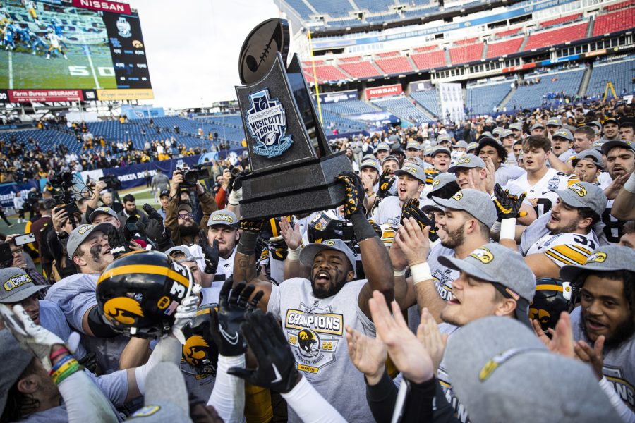 Iowa players celebrate with the 2022 TransPerfect Music City Bowl trophy during the 2022 TransPerfect Music City Bowl between Iowa and Kentucky at Nissan Stadium in Nashville. The Hawkeyes defeated the Wildcats, 21-0.