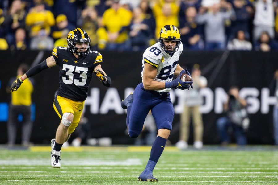 Dec 4, 2021; Indianapolis, IN, USA; Michigan Wolverines tight end Erick All (83) catches the ball while Iowa Hawkeyes defensive back Riley Moss (33) defends in the second half at Lucas Oil Stadium. Mandatory Credit: Trevor Ruszkowski-USA TODAY Sports