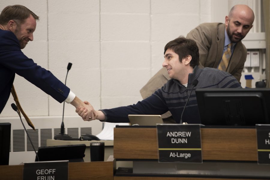 Andrew Dunn takes his new seat as councilor and shakes hands with City Attorney Eric Goers during an Iowa City Council special formal meeting in the Emma J. Harvat Hall in City Hall on Jan. 10, 2023.
