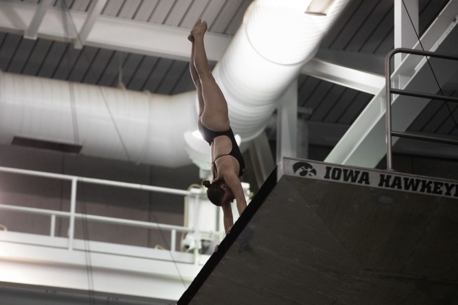 Iowa diver Claire Hartley does a handstnad to start her dive during a swim and dive meet between Iowa and Illinois in Iowa City on Friday, Jan 13, 2023. The Fighting Illini won the duel meet against the Hawkeyes, 46-45.