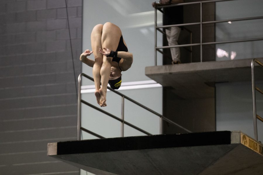 Iowa diver Geneva Pauley tucks into a pike position during a dive during a swim and dive meet between Iowa and Illinois in Iowa City on Friday, Jan 13, 2023. The Fighting Illini won the duel meet against the Hawkeyes, 46-45.