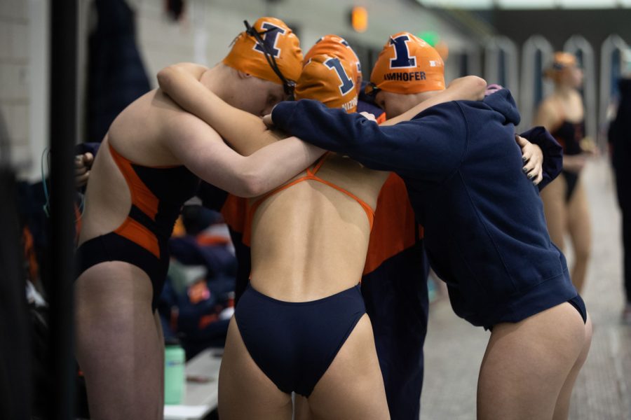 Members of an Illinois relay team huddle together before the 400 yard medley relay during a swim and dive meet between Iowa and Illinois in Iowa City on Friday, Jan 13, 2023. The Fighting Illini won the duel meet against the Hawkeyes, 46-45.