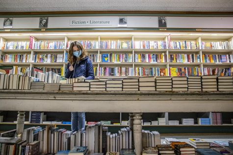 First-year University of Iowa student Meredith Onions looks through a book at Prairie Lights Book and Cafe is seen in Iowa City on Tuesday, Jan. 17, 2022. 