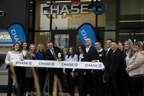 Chase Bank employees pose for photos before Branch Manager Sean Peterson cuts the ribbon at a ceremony at Chase Bank in downtown Iowa City Wednesday, Jan. 18, 2023.