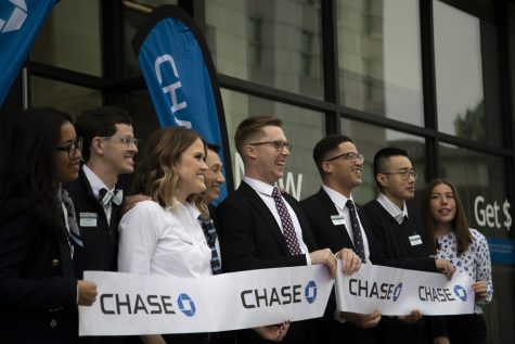 Chase Bank employees hold up the cut ribbon during a ribbon cutting ceremony at Chase Bank in downtown Iowa City Wednesday, Jan. 17, 2023. (Matt Sindt/The Daily Iowan)