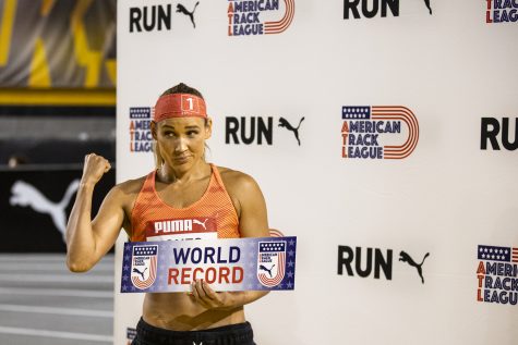 Lolo Jones, who ran unattached in the women’s 60-meter hurdles, flexes with a sign reading, “World Record,” during the Larry Wieczorek Invitational at the Iowa Indoor Track Facility in Iowa City on Saturday, Jan. 21, 2023. The 40-year-old Olympian set the fastest time ever recorded at her age for the 60-meter women’s hurdles with a time of 8.35. The meet also hosted the Hawkeye Pro Classic for the American Track League.