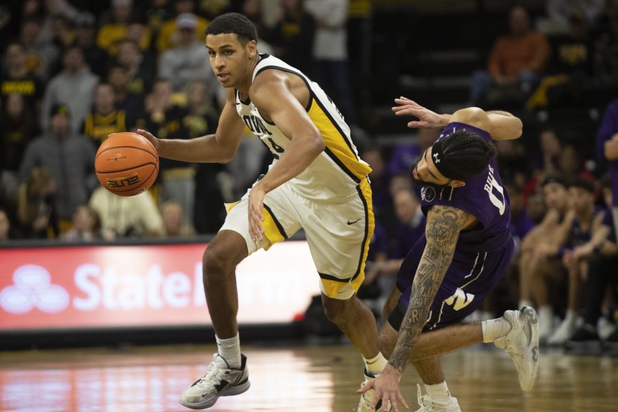 Iowa forward Kris Murray runs past Northwestern guard Boo Buie during a men’s basketball game between Iowa and Northwestern at Carver-Hawkeye Arena in Iowa City on Tuesday, Jan. 31, 2023. The Hawkeyes defeated the Wildcats, 86-70.