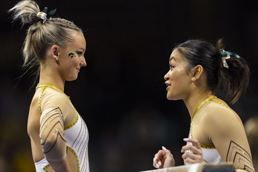 Iowa’s Alexa Ebeling (left) listens to Iowa’s Adeline Kenlin (right) before competing on beam during a gymnastics meet between No. 18 Iowa and Rutgers at Carver-Hawkeye Arena on Saturday, Feb. 18, 2023. The Hawkeyes defeated the Scarlet Knights 196.200-195.125.
