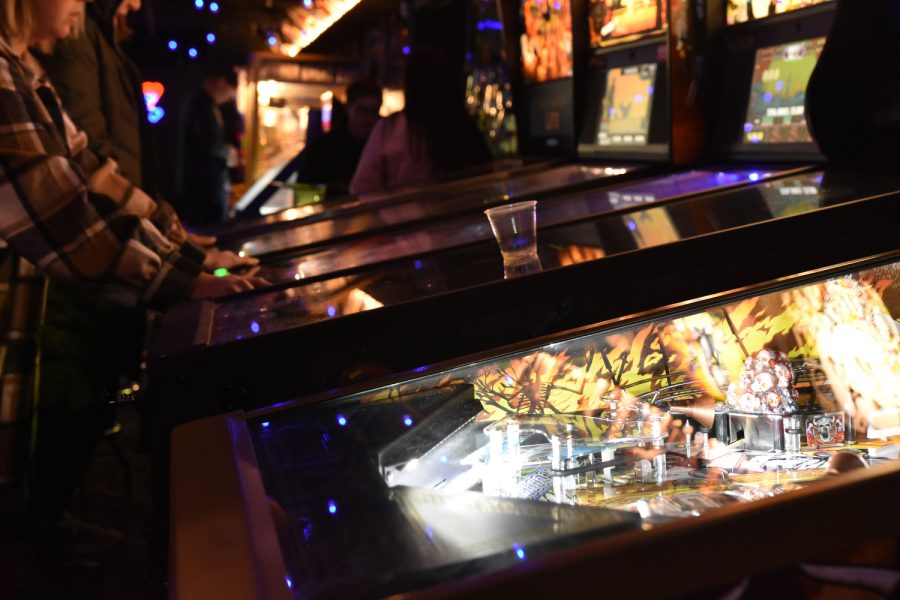 Customers play one of six pin ball machines in Double Tap bar in Iowa City. Double Tap opened its door in the summer of 2022 and features many vintage video gaming machines along with a full service bar. 