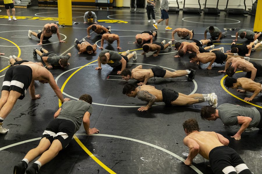 Iowa wrestlers conduct team push-ups at the end of practice in the Iowa wrestling room at Carver Hawkeye Arena on Nov. 1, 2022. 