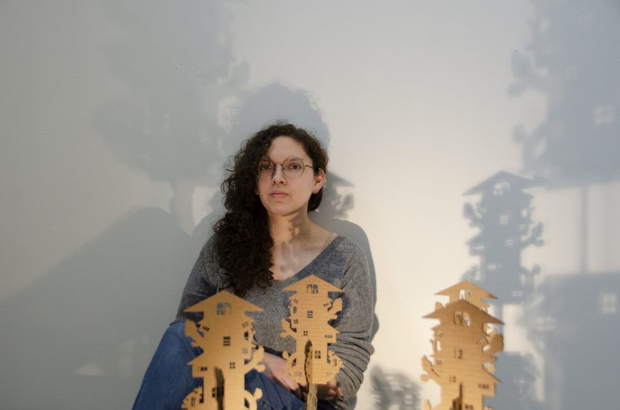 Stevie Haley Delgado sits by her sculpture in the Visual Arts Building on Feb. 27, 2023.