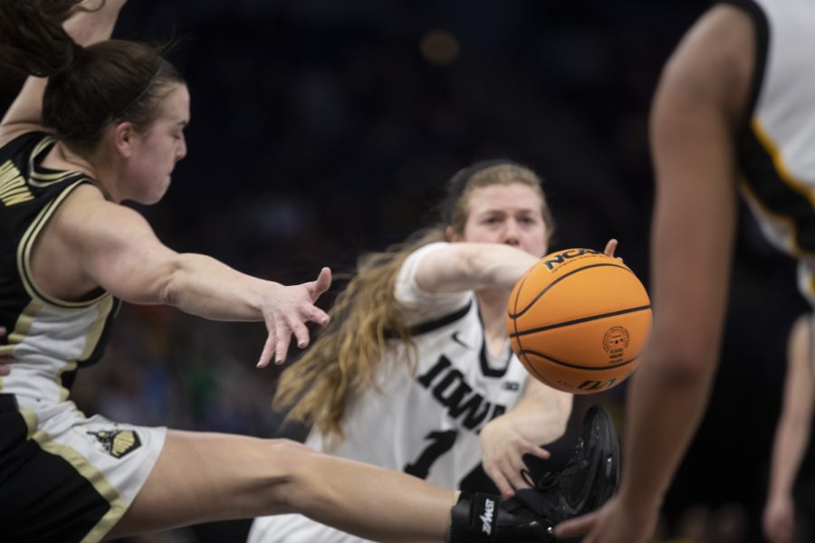 Iowa guard Molly Davis passes the ball to Iowa forward Hannah Stuelke during a women’s basketball game between No. 7 Iowa and Purdue at Target Center in Minneapolis on Friday, March 3, 2023. The Hawkeyes defeated the Boilermakers, 69-58.