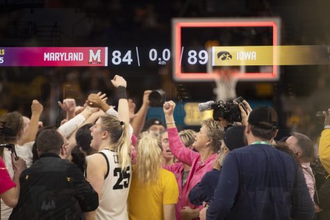In this multiple exposure image, the final score is seen while Iowa teammates celebrate after winning a women’s basketball game between No. 7 Iowa and No. 5 Maryland at Target Center in Minneapolis on Saturday, March 4, 2023. The Hawkeyes defeated the Terrapins, 89-84.