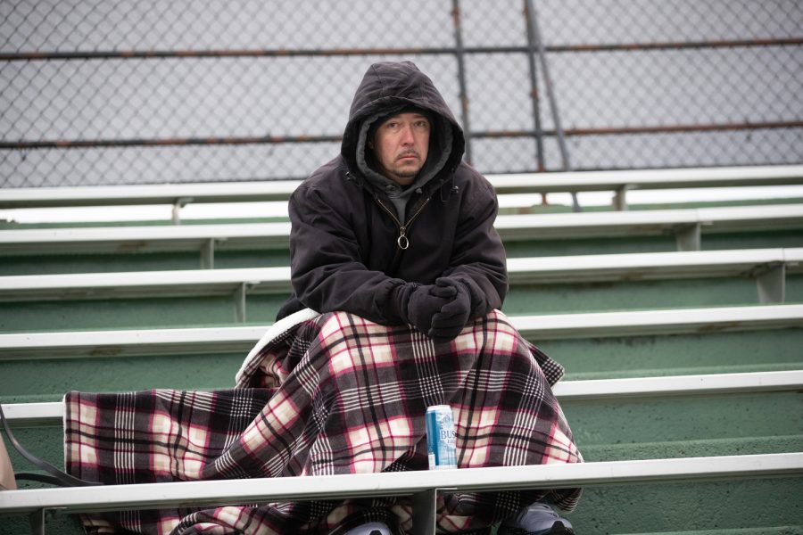 A fan sits in the cold during a baseball game at Duane Banks Baseball Stadium in Iowa City on Tuesday, March 7, 2023. The Hawkeyes defeated the Kohawks, 8-2.