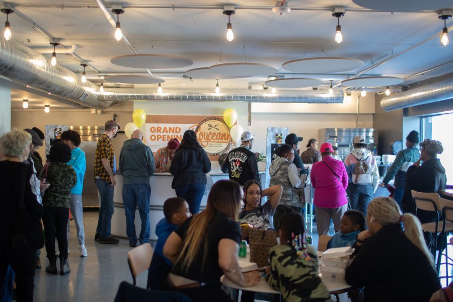 People gather to order and eat food during the grand opening of Royceann’s Soul Food Restaurant in the South District Market in Iowa City on Saturday, March 25, 2023. 