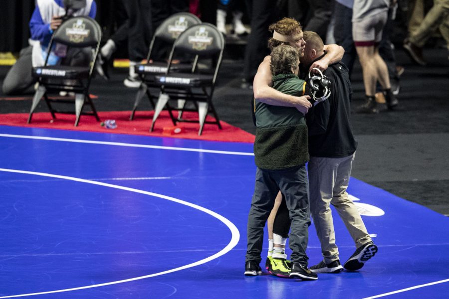 No. 14 seeded 197-pound Iowas Jacob Warner hugs Iowa associate head coach Terry Brands and Iowa assistant coach Ryan Morningstar after wrestling No. 4 seeded 197-pound Riders Ethan Laird during session five of the NCAA Wrestling Championships at BOK Center in Tulsa, Okla. on Saturday, March 18, 2023. Warner defeated Laird by decision, 7-3, placing fifth in the tournament achieving all-American status.