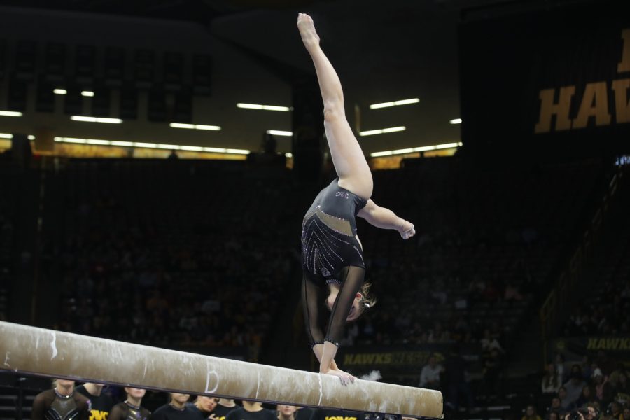 Iowa gymnast Allison Zuhlke does a back handspring while competng on the beam during a gymnastics meet between Iowa and Minnesota in Iowa City on Friday, Jan. 27, 2023. The Hawkeyes and the Gophers tied with each getting a score 196.875.