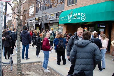 A crowd gathers outside of Bo’James Food & Drink in search of Will Ferrell in downtown Iowa City on March 8, 2023.