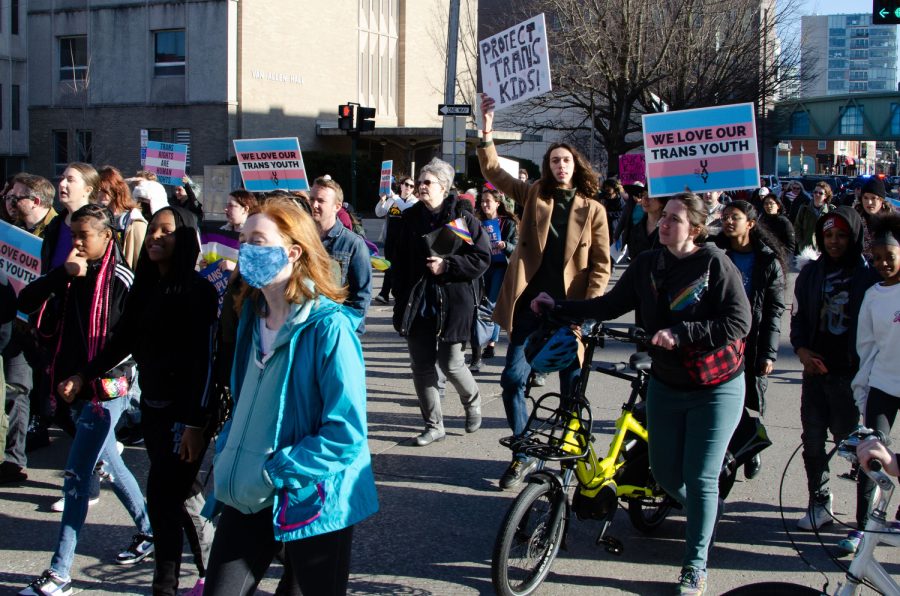 Protestors cross at the intersection of North Dubuque Street and East Jefferson Street on Saturday, April 1, 2023.