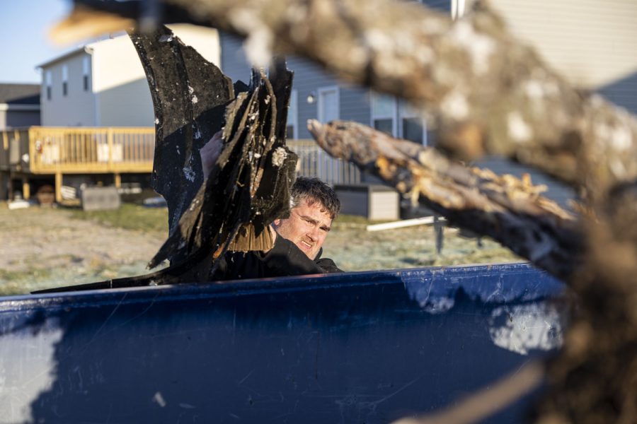 Yancey Forkner puts debris in a dumpster in Hills, Iowa on Saturday, April 1, 2023 after a tornado went through parts of the town on Friday. The tornado impacted a new development in the city of 902 people. “I’ve never been through one of these before, it’s scary.” Forkner said.