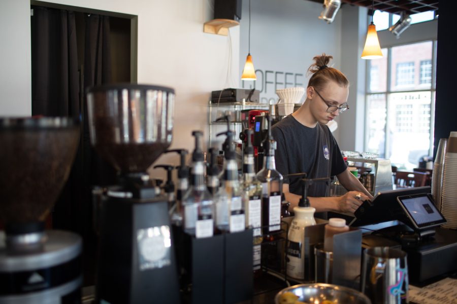 Michael Martin, lead barista at Coffee Emporium in Iowa City take a customers order on Wednesday, April 12, 2023. Coffee Emporium, formerly High ground Coffee, recently underwent a name change due to new ownership. (Emily Nyberg/ The Daily Iowan)