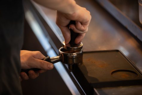 Michael Martin, lead barista at Coffee Emporium in Iowa City, makes coffee on Wednesday, April 12, 2023. Coffee Emporium, formerly High ground Coffee, recently underwent a name change due to new ownership. 