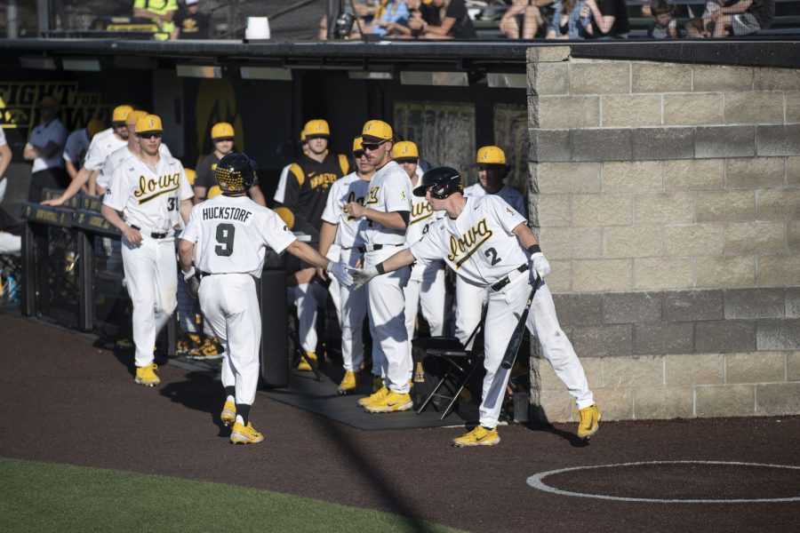 Iowa outfielder Kyle Huckstorf high fives teammates during a baseball game between Iowa and Wisconsin-Milwaukee at Duane Banks Field on Wednesday, April 12, 2023. The Hawkeyes defeated the Panthers, 12-1.