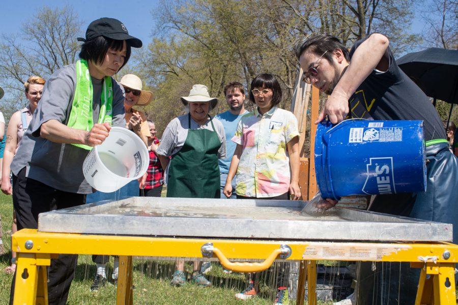 Masami Igarashi and Hideaki Taki from the Echizen papermaking village in Japan prepare a canvas during a Japanese papermaking festival in Iowa City on Friday, April 14, 2023.