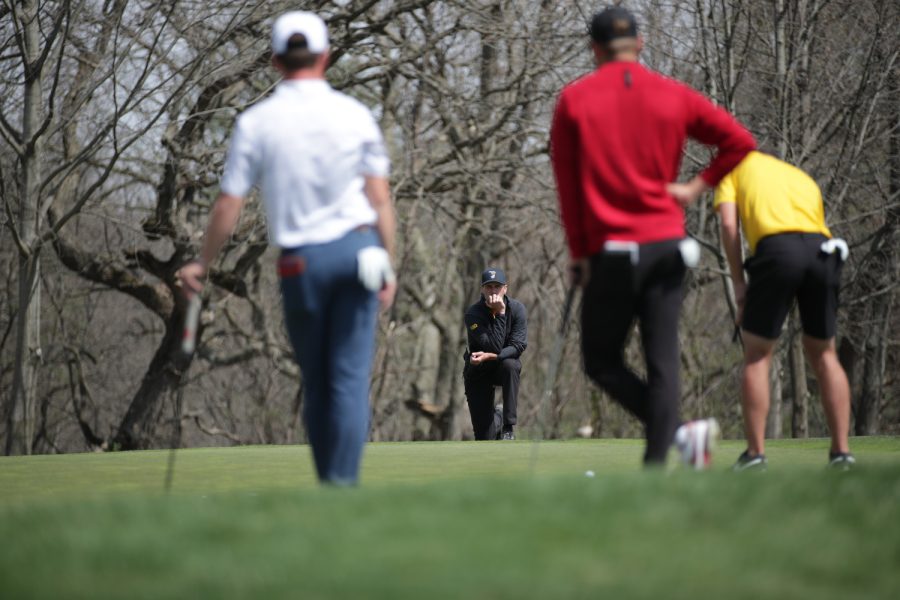Iowa head coach Tyler Stith watches Hogan Hansen try to make a putt  during the Hawkeye invitational at Finkbine Golf Course in Iowa City on Saturday, April 15, 2023. The Hawkeyes lead after all three rounds of the two-day tournament, and took both the team and individual sweepstakes with Iowas Mac McClear taking the individual title.