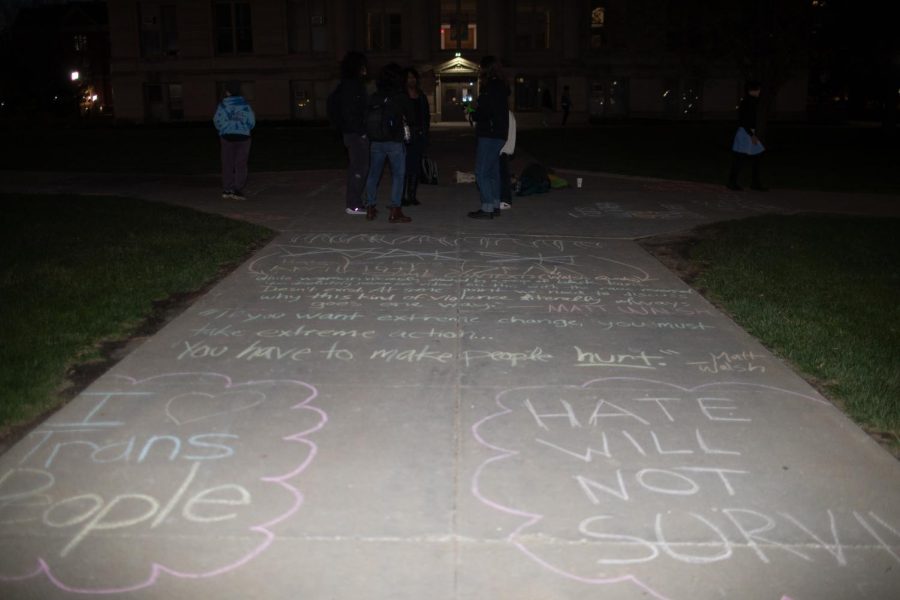 People gather on the Pentacrest in Iowa City to support the transgender community through chalk writing on Monday evening, April 17, 2023. One chalk writing reads, If you want extreme change, you must take extreme action... you have to make people hurt, a quote from right-wing political commentator Matt Walsh who is set to deliver a speech at the Iowa Memorial Union on Wednesday.