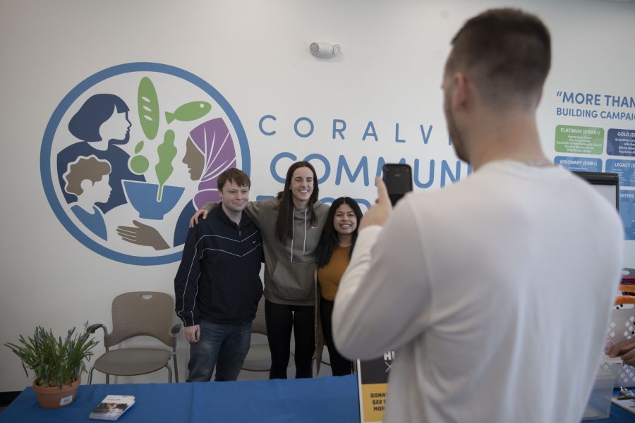 Iowa guard Connor McCaffery takes a photo of Caitlin Clark  with fans during a charity event at the Coralville food pantry on Friday, April 21, 2023.