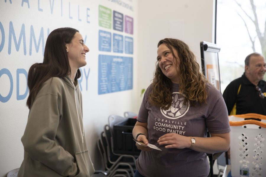 Iowa guard Caitlin Clark interacts with a Food Pantry worker during a charity event at the Coralville food pantry on Friday, April 21, 2023.