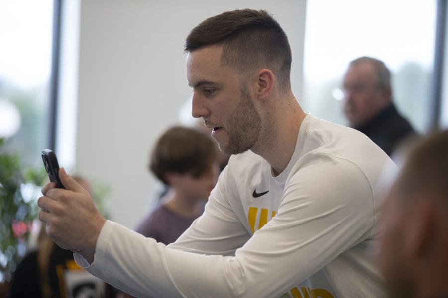 Iowa guard Connor McCaffery takes a photo during Caitlin Clark’s charity event at the Coralville food pantry on Friday, April 21, 2023.