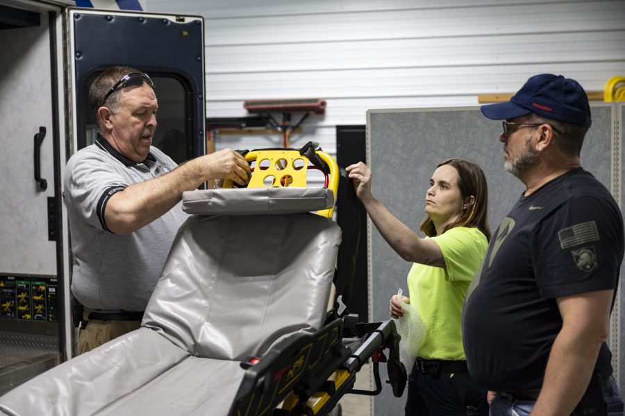 Dan Conry, Jen Martin and Jim Ingham adjusts a stretcher at the ambulance base in Columbus Junction, Iowa on Friday, March 24, 2023. 
