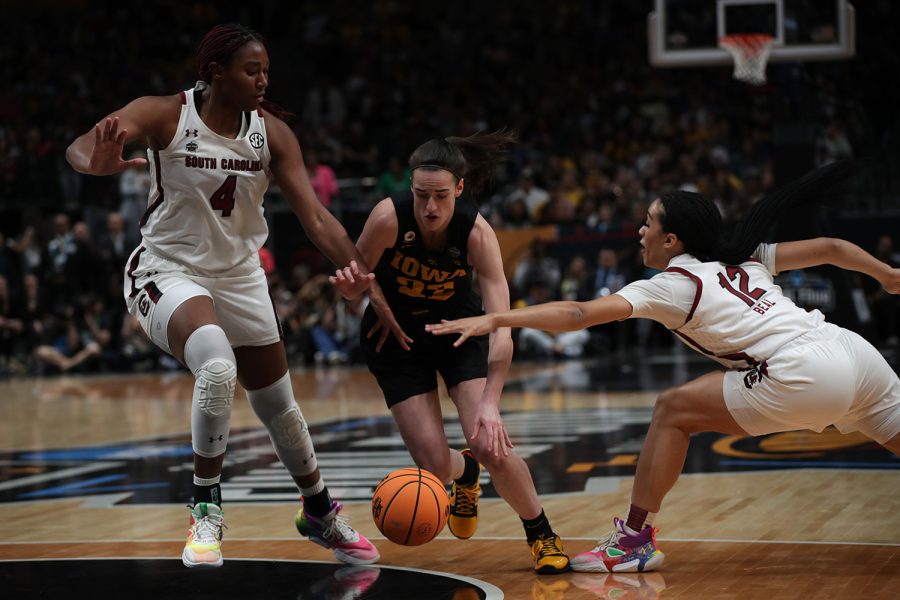Iowa guard Caitlin Clark dribbles between South Carolina’s Aliyah Boston and Brea Beal during a 2023 NCAA women’s Final Four game between No. 1 South Carolina and No. 2 Iowa at American Airlines Arena in Dallas, Texas, on Friday, March 31, 2023. Clark completed eight assists. The Hawkeyes defeated the Gamecocks, 77-73, to advance to the National Championship Game. 