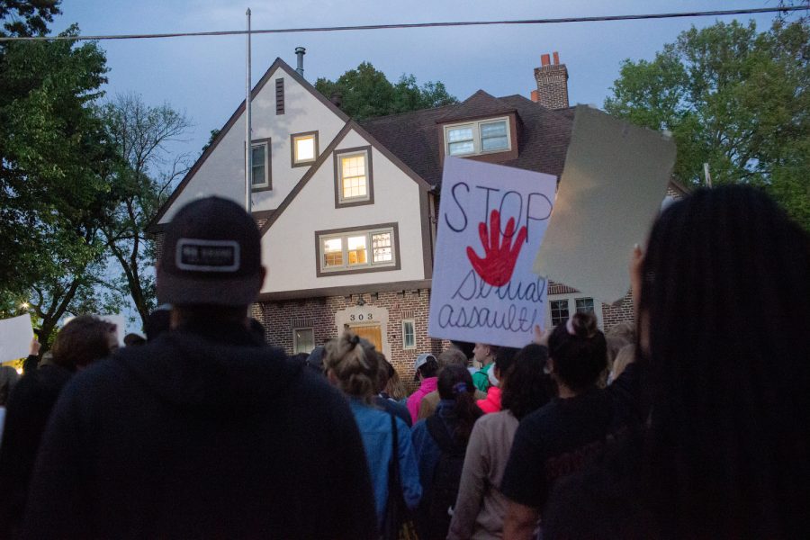 People stand in front of Phi Delta Gamma during a protest following sexual assault allegations against the University of Iowa’s chapter of Phi Delta Gamma on Tuesday August 31 2021.