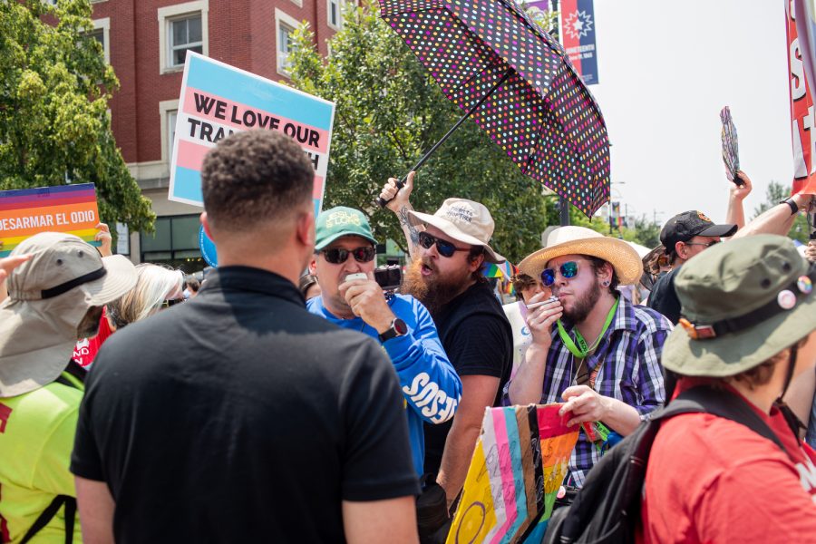 Pride attendants interact with a religious protestor during the 2023 Pride Parade & Festival in downtown Iowa City on Saturday, June 17, 2023.