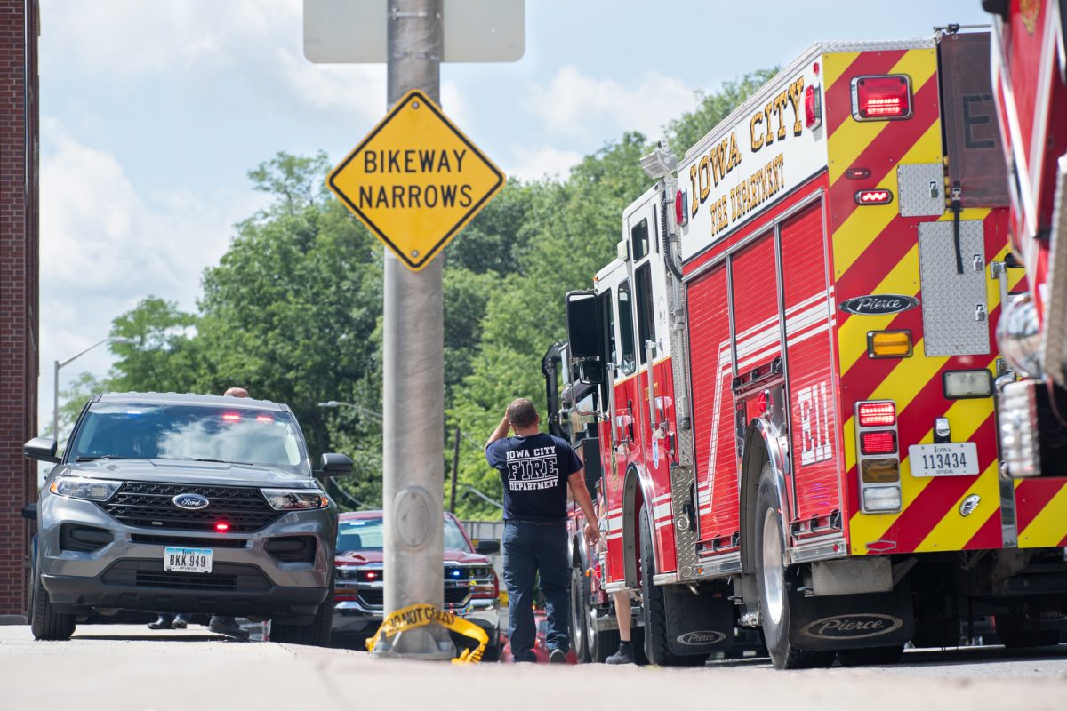 An Iowa City Firefighter walks away from a Fire Truck at a crime scene on the corner of west Burlington st. and south Riverside Drive on Thursday, July 13 2023. 