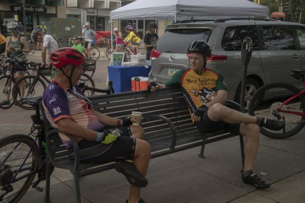 Dean Kidd and Kevin Wyne hold a conversation during RAGBRAI in Iowa City on July 29, 2023. Multiple vendors set up on Clinton Street to give breakfast to bikers.