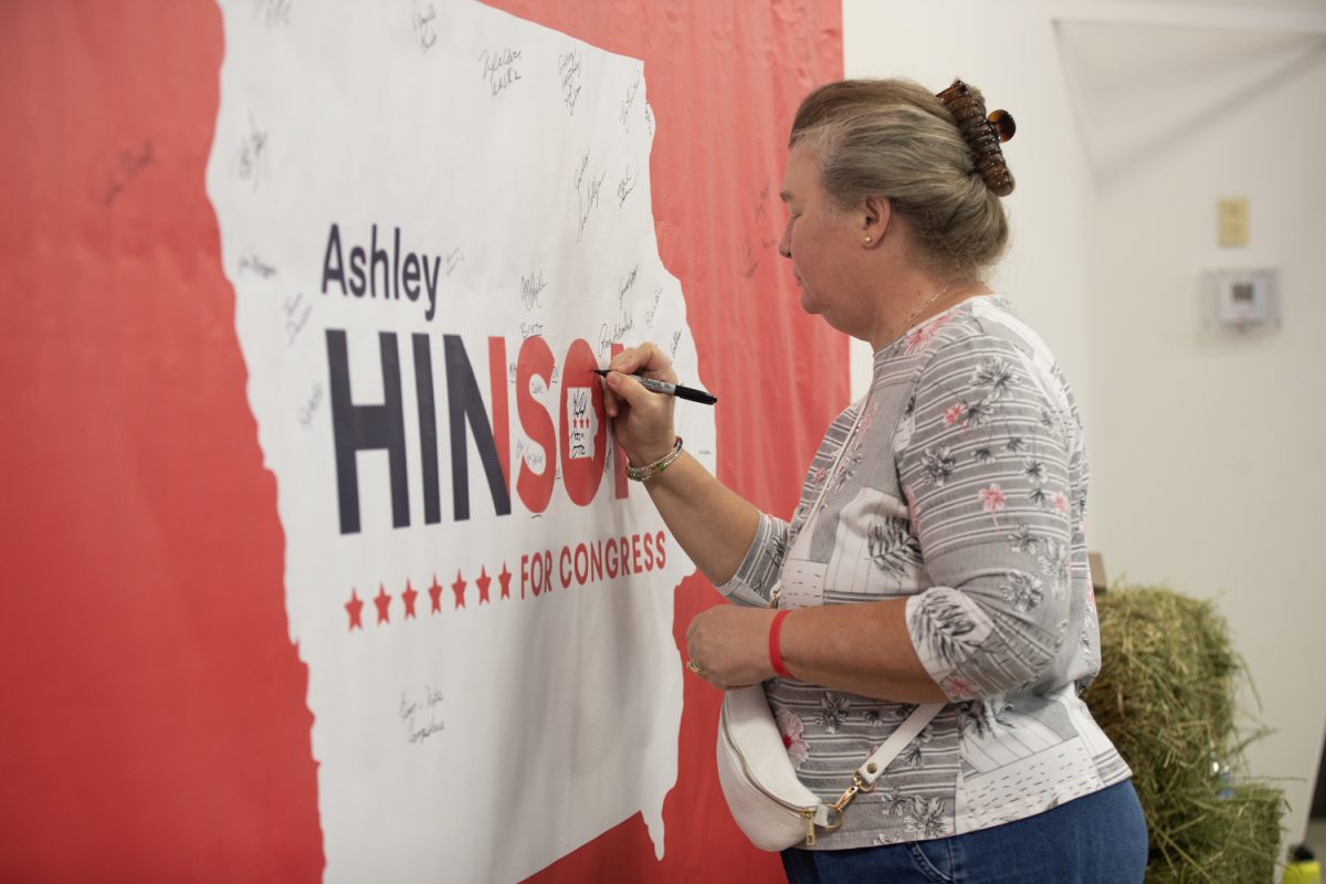 An attendee signs a poster during Ashley Hinson’s BBQ Bash at Hawkeye Downs in Cedar Rapids, Iowa on Sunday, August 6, 2023.