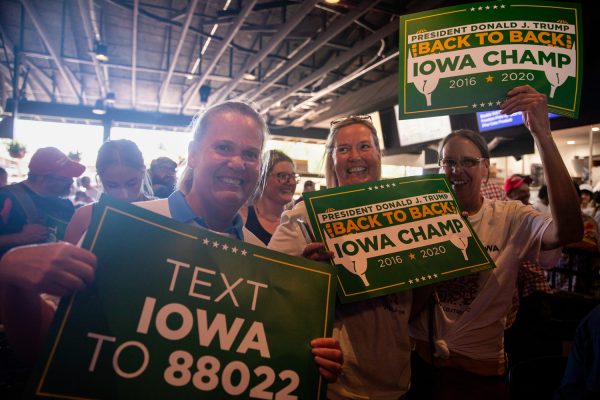 Three sisters pose for a photo while waiting for former president Donald Trump to speak during the 2023 Iowa State Fair in Des Moines, Iowa, on Saturday, August 12, 2023.
