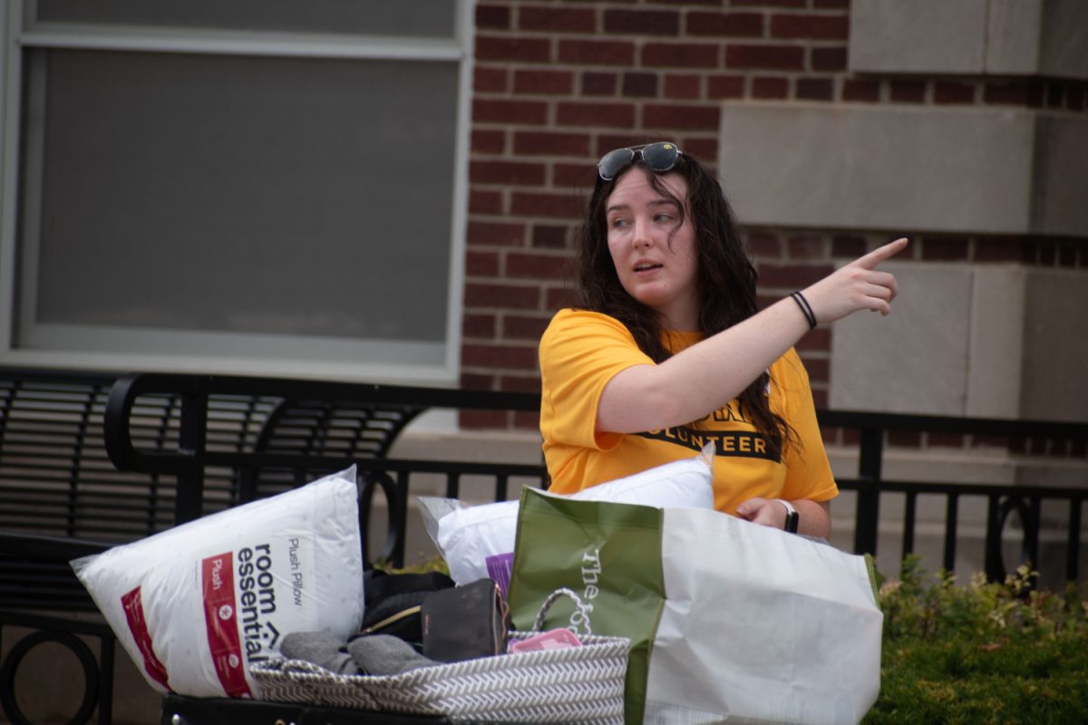 An Iowa volunteer directs new students in Currier hall in Iowa City on Sunday August 13, 2023.