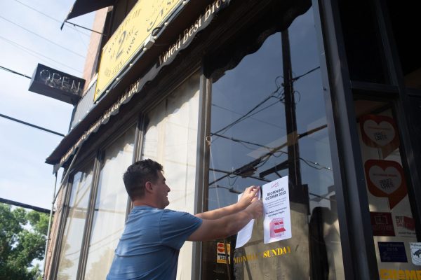 Rob Miller, a freelance marketer working with Gold Cap Hospitality, posts an official announcement paper of the new ownership and October reopening of Hamburg Inn No. 2 in Iowa City, on Monday, Aug. 21, 2023. 