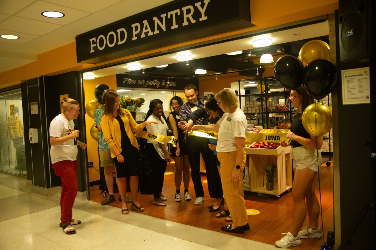 Organizers of the Iowa Memorial Union food pantry cut the ribbon during the pantrys grand opening in Iowa City on Thursday Aug. 24, 2023. 