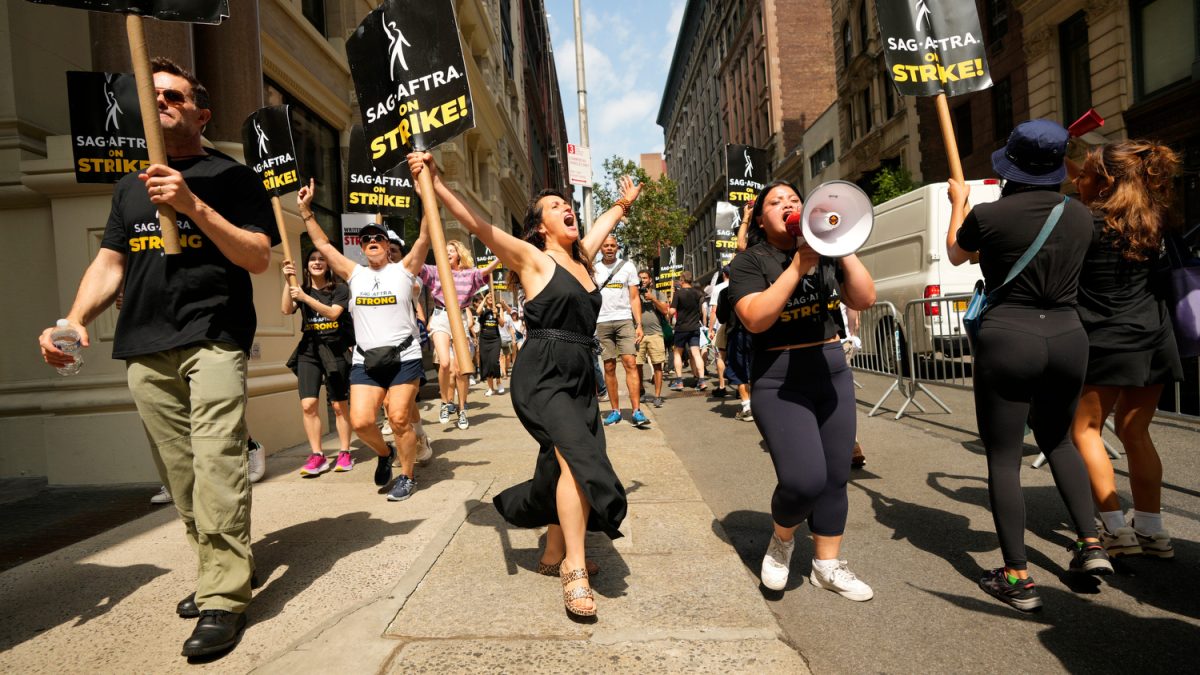 Actress Daniella Rabbani (hands raised) was one of more than 100 people from SAG-AFTRA picketing on East 19th St. in front of a Netflix office and a Warner Brothers Discovery office. Thursday, July, 20, 2023