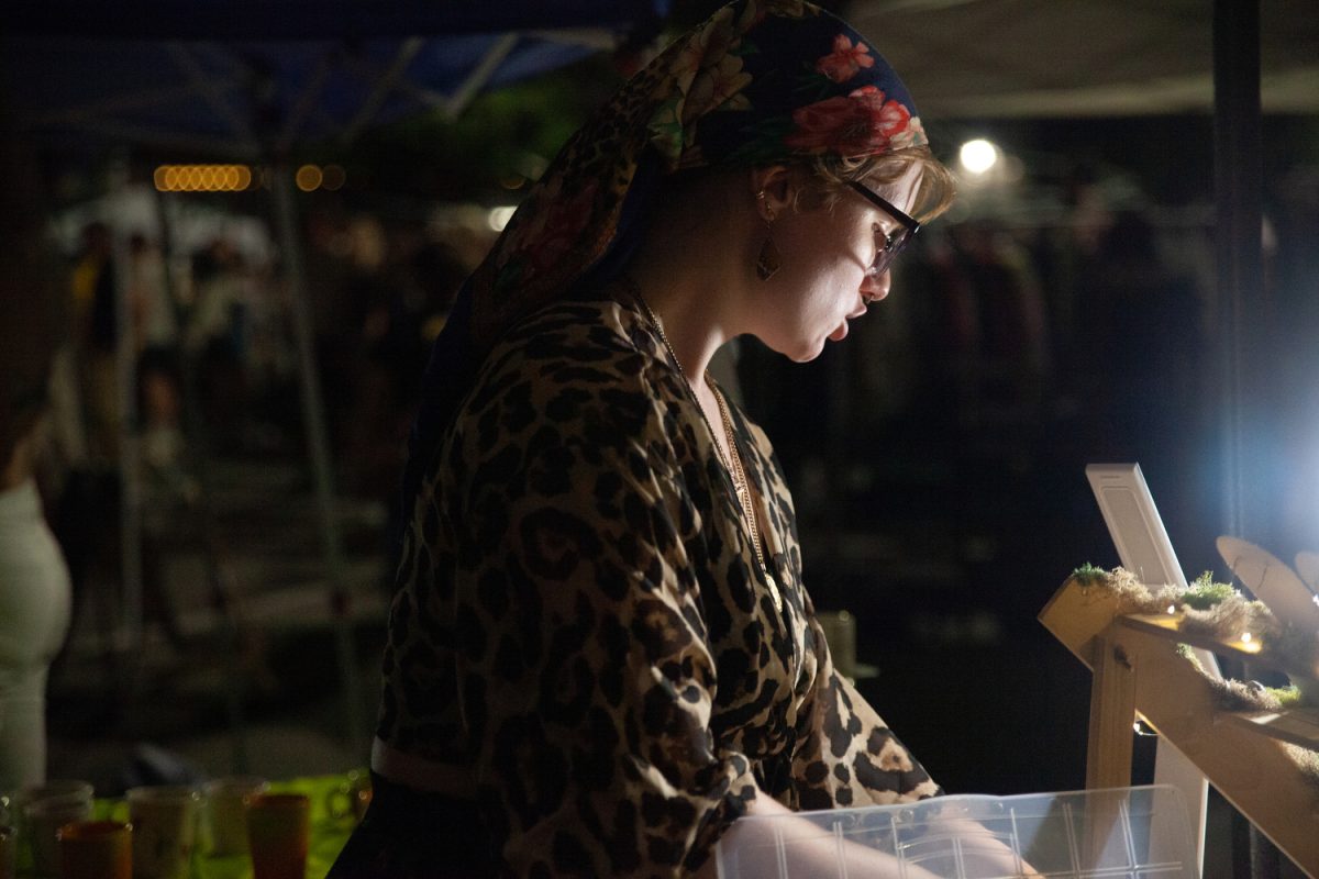 Penelope Wilkins talks with a customer while hosting a booth at the Northside Night Market organized by IC Flea in the James Theater in Iowa City on Friday, September 1, 2023. 