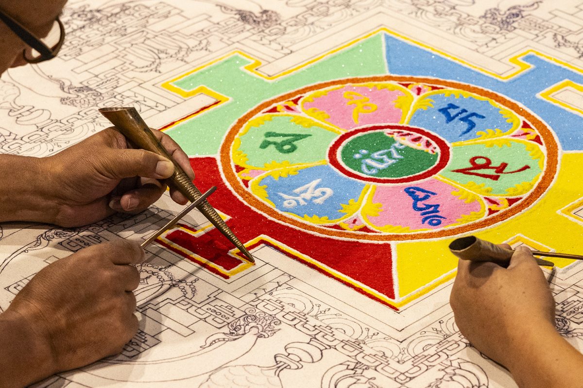 Drupon Thinley Ningpo and Lama Kalsang work during a viewing of the sacred art of Tibetan Buddhist Lamas creating a sand mandala at the Levitt Gallery in Art Building West on the University of Iowa campus in Iowa City on Tuesday, Sept. 5, 2023. The viewing of the making of the sand mandala occurred Sept. 5-8 with a procession on Friday. Dating back to about 2,500 years ago, the mandala is translated as “World of Harmony.” In the mandala, the five Buddha families are represented by the colors white: faith, yellow: effort, red: memory, green: meditation, and blue: wisdom. 