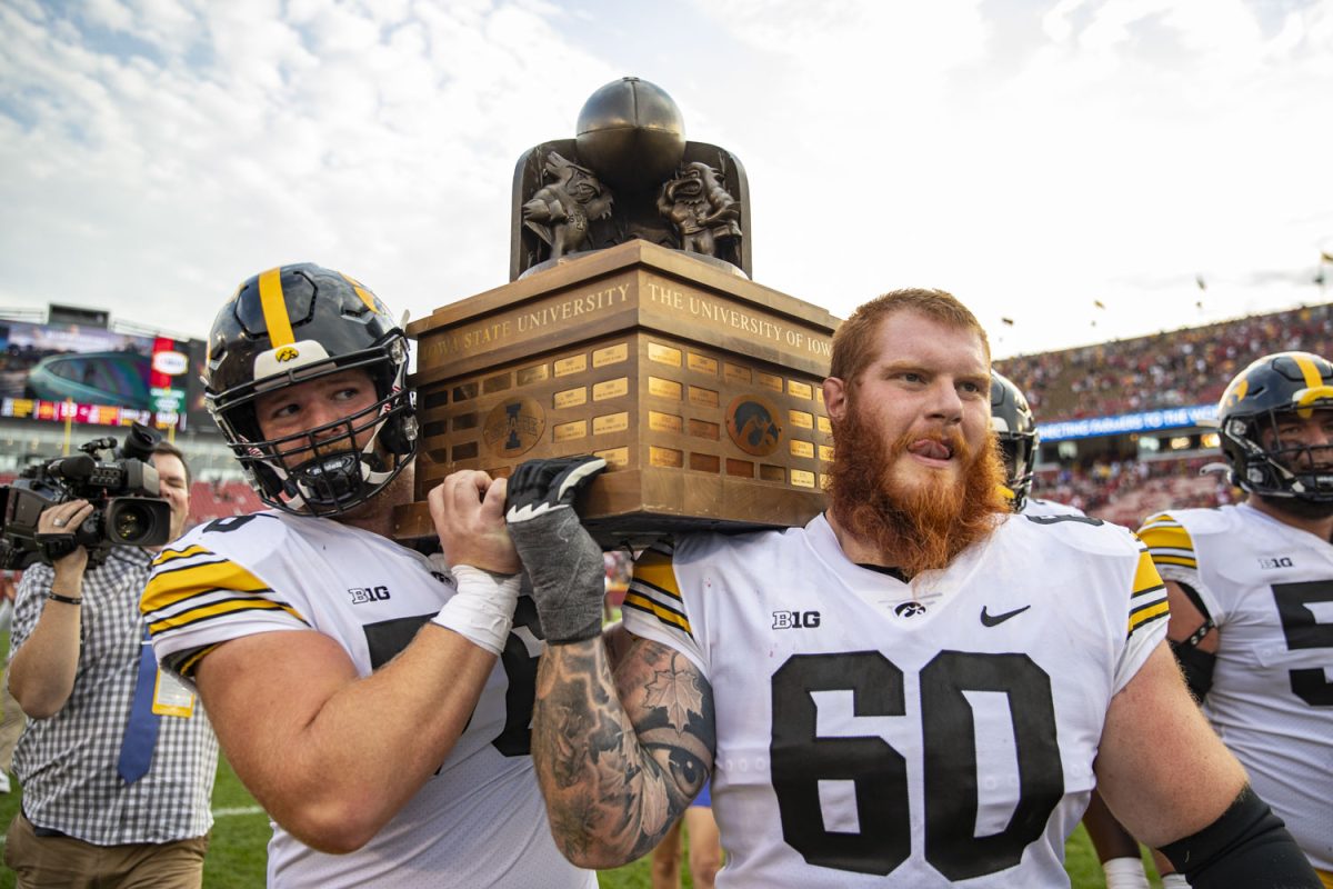 Iowa offensive linemen Nick DeJong and Rusty Feth carry the Cy-Hawk Trophy after a Cy-Hawk football game between Iowa and Iowa State at Jack Trice Stadium in Ames on Saturday, Sept. 9, 2023. The Hawkeyes defeated the Cyclones, 20-13.