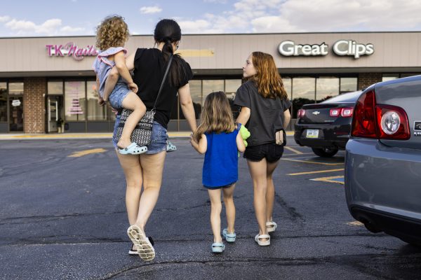 Lexie Olgren, 28, and her three daughters: Miley, 3, Isabelle, 4, and Aubree, 11, walk toward Great Clips in Ankeny, Iowa, on Thursday, Sept. 14, 2023. In the fall of 2022, Iowa’s only inpatient eating disorder clinic closed at the University of Iowa Hospitals and Clinics. Olgren was a patient when she was 26 years old, and said the program is crucial to helping those with eating disorders and is upset about its closing. Olgren said she still struggles with disordered eating daily. She said it sucks that her daughters have to watch her go through that.