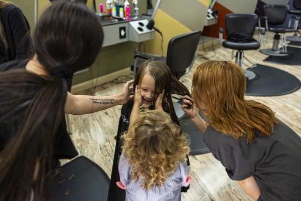 Lexie Olgren, Miley Olgren, 3, and Aubree Olgren, 11, admire Isabelle Olgren’s haircut at Great Clips in Ankeny, Iowa, on Thursday, Sept. 14, 2023. In the fall of 2022, Iowa’s only inpatient eating disorder clinic closed at the University of Iowa Hospitals and Clinics. Olgren, 28, was a patient when she was 26 years old, and said the program is crucial to helping those with eating disorders and is upset about its closing.